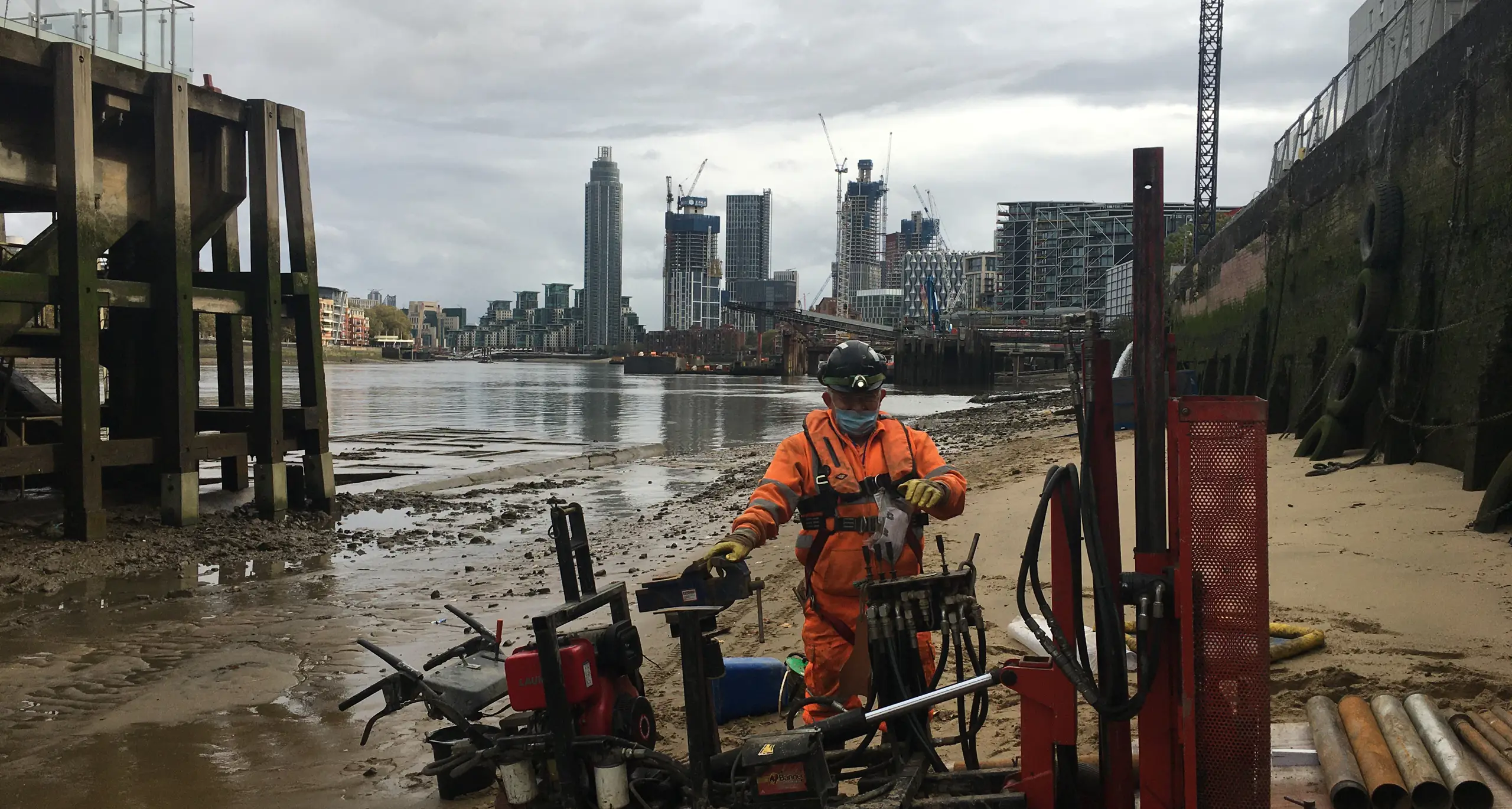 Drilling operative completing a window sample borehole on the bank of the Thames