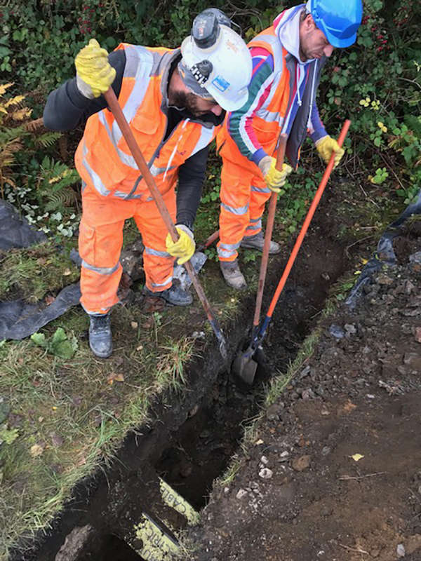 Two site operatives examining a pit